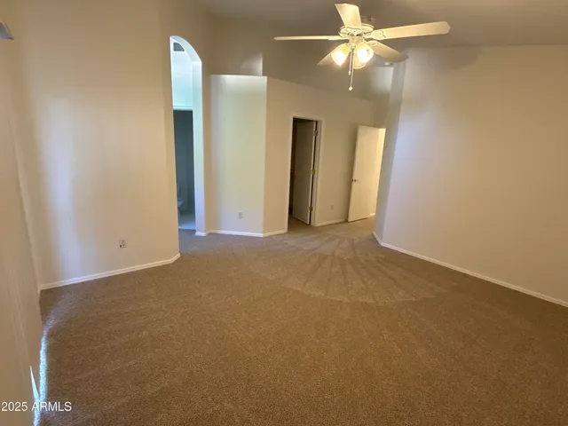 an empty room with closet and a chandelier fan