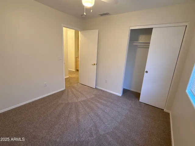 an empty room with a window and a fan