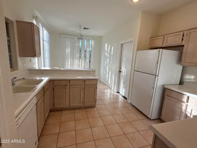 a kitchen with a sink a refrigerator and cabinets