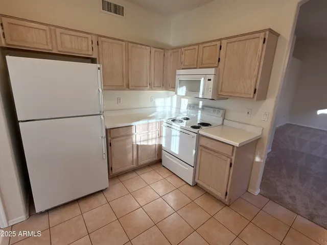 a kitchen with a refrigerator sink stove and cabinets