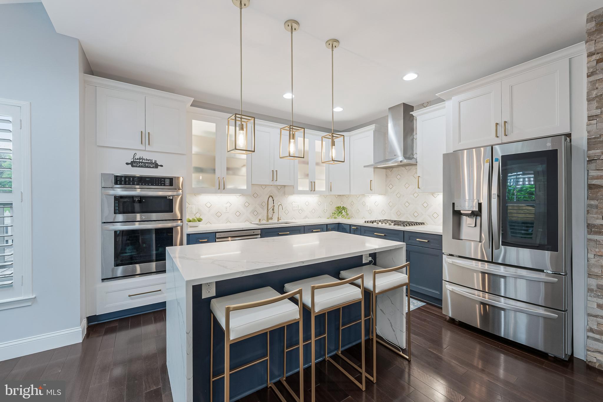 19599 Aspendale Square Ashburn, VA 20147 - Photo 20 of 56 a kitchen with kitchen island a wooden floor and white appliances