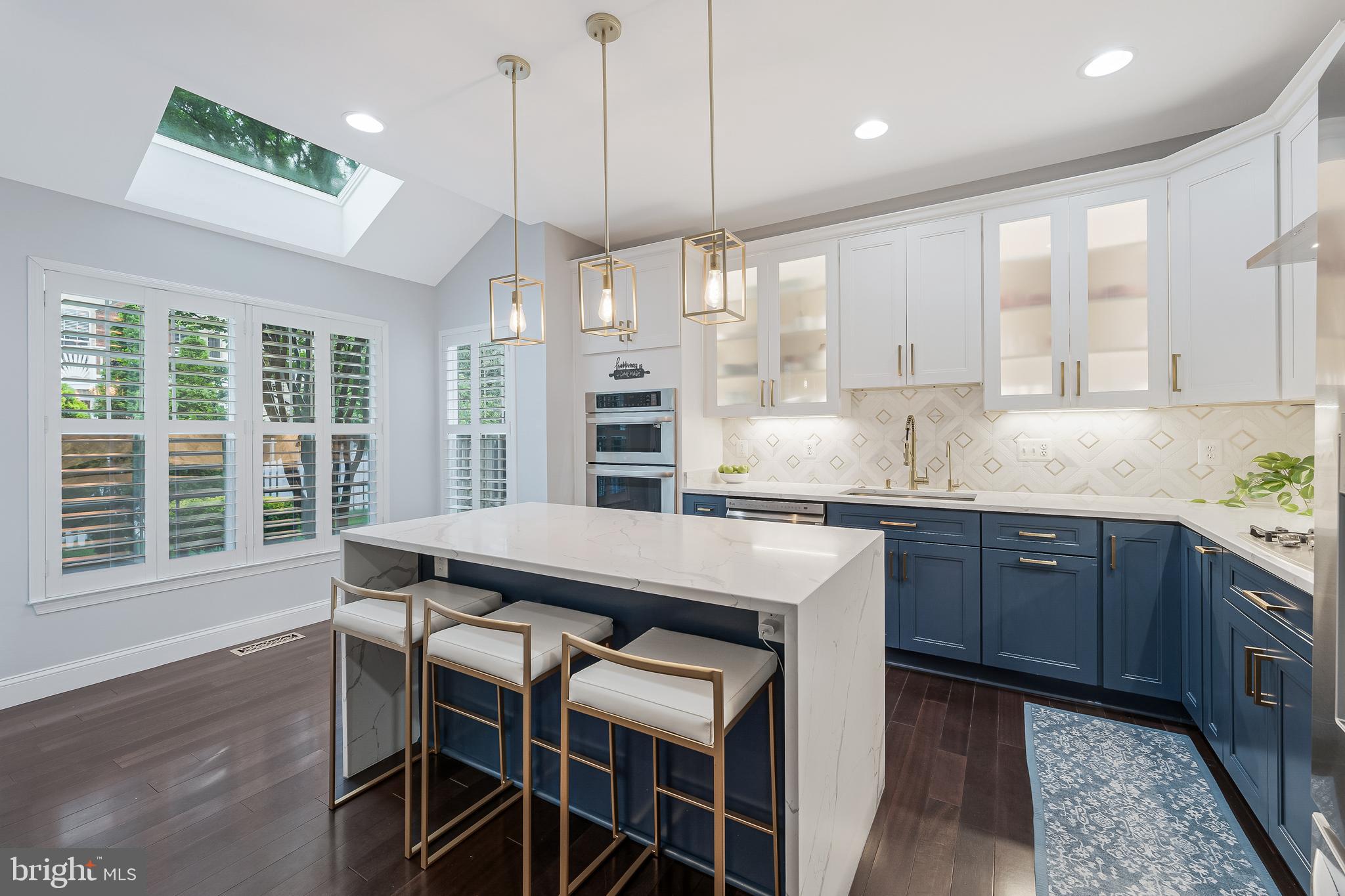 19599 Aspendale Square Ashburn, VA 20147 - Photo 2 of 56 a kitchen with granite countertop a table chairs a sink dishwasher refrigerator and wooden cabinets