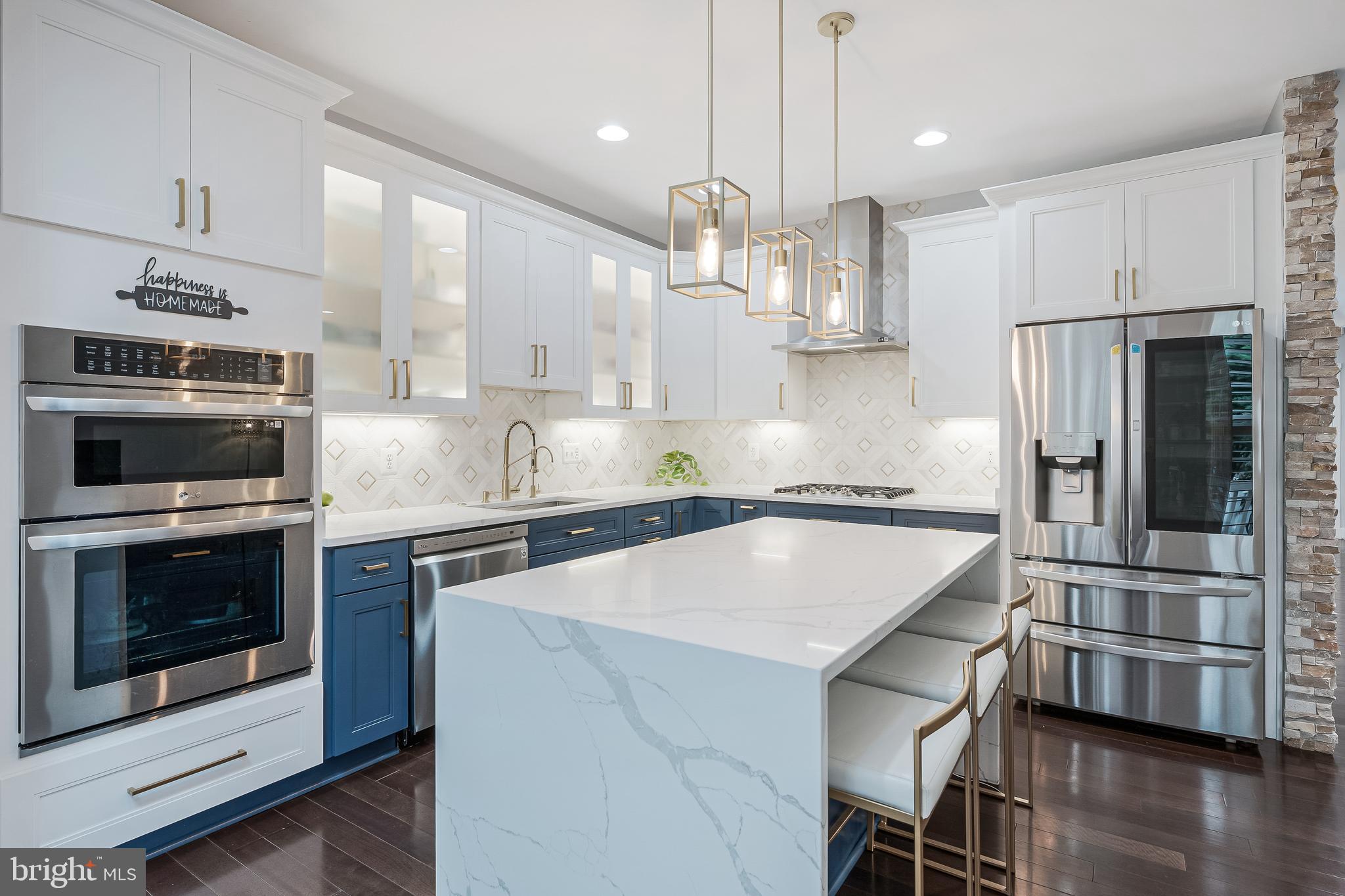 19599 Aspendale Square Ashburn, VA 20147 - Photo 9 of 56 a kitchen with kitchen island a stove a microwave and a refrigerator
