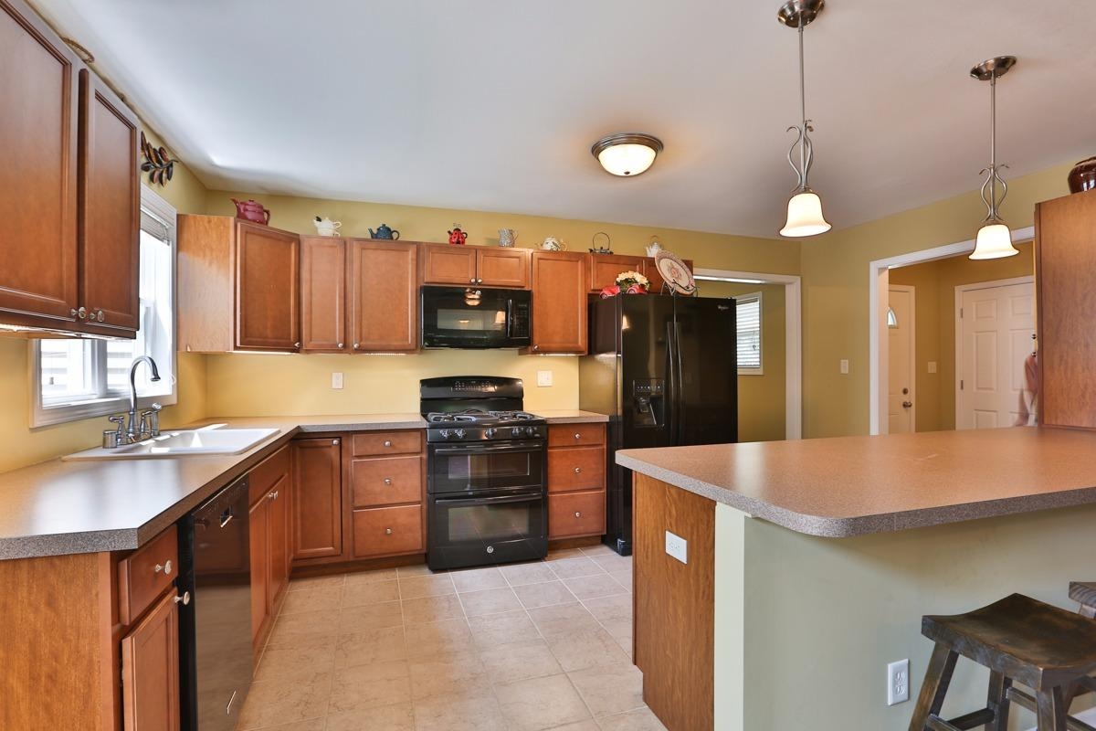 1035 North Indiana Street Griffith, IN 46319 - Photo 3 of 10 a kitchen with stainless steel appliances granite countertop a sink a stove and a refrigerator