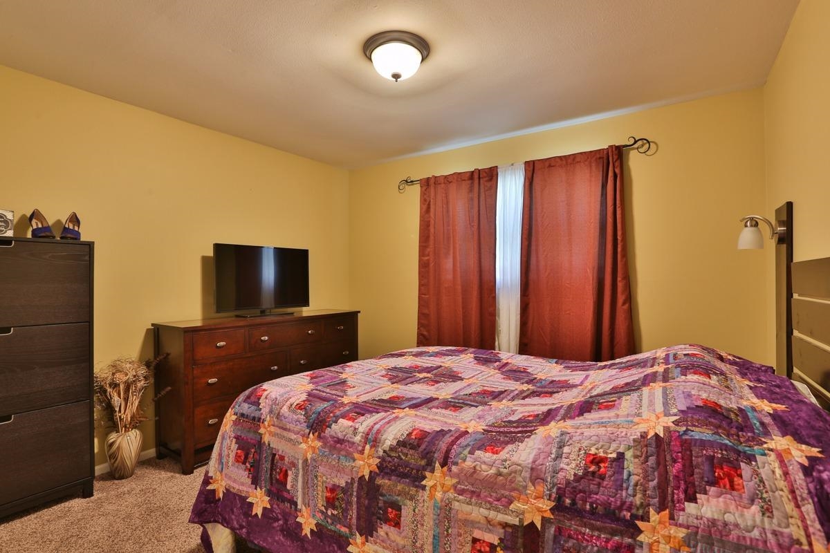 1035 North Indiana Street Griffith, IN 46319 - Photo 6 of 10 a bedroom with a bed and a flat screen tv