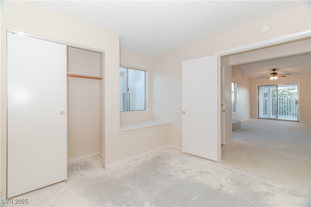 2225 Pebble Creek Lane Laughlin, NV 89029 - Photo 28 of 87 Second bedroom with unfinished concrete floors, a textured ceiling, and a closet