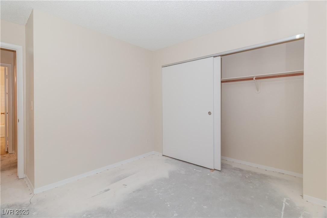 2225 Pebble Creek Lane Laughlin, NV 89029 - Photo 34 of 87 Third bedroom featuring a closet, a textured ceiling, and concrete flooring