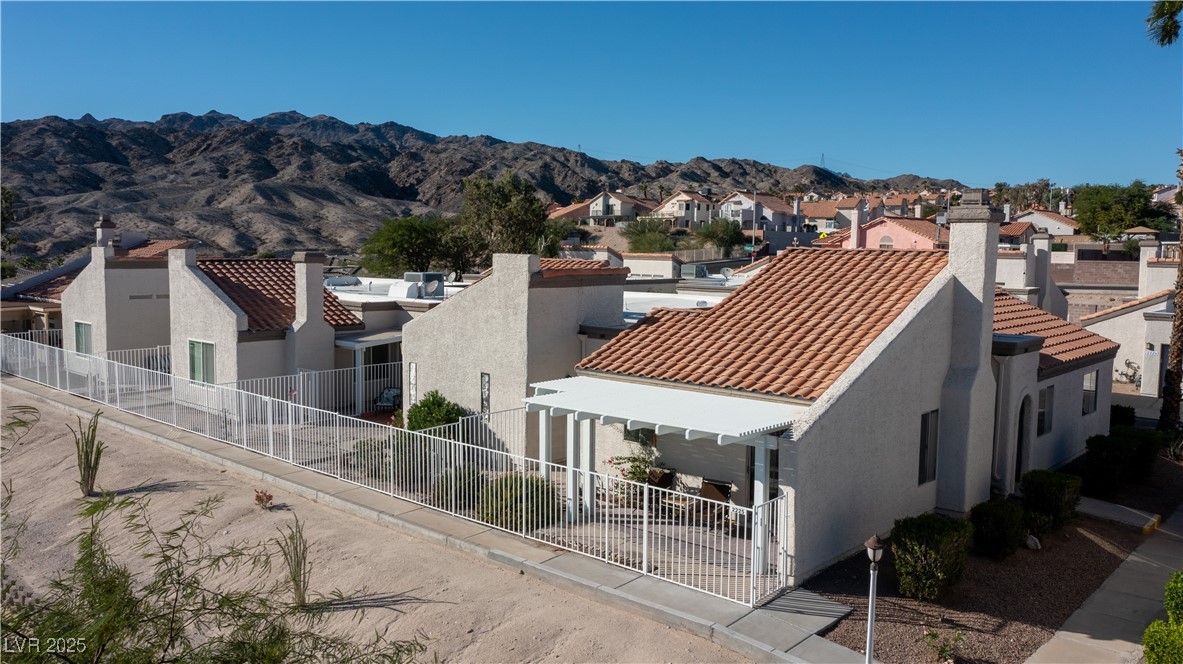 2225 Pebble Creek Lane Laughlin, NV 89029 - Photo 71 of 87 Back of house with a residential view, stucco siding, a tile roof, and a mountain view
