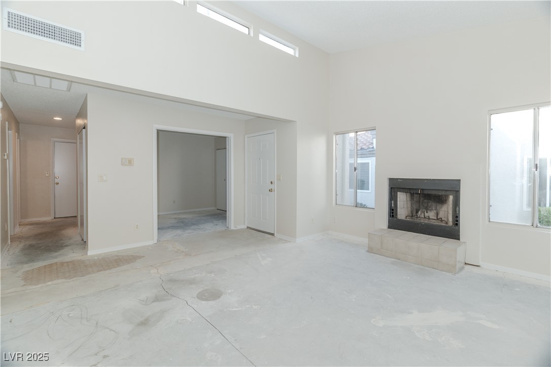 2225 Pebble Creek Lane Laughlin, NV 89029 - Photo 8 of 87 Unfurnished living room with a towering ceiling and a tiled fireplace
