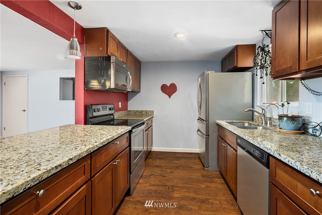 23925 7th Avenue West Bothell, WA 98021 - Photo 8 of 28 a kitchen with stainless steel appliances granite countertop a sink and stove