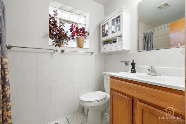 a bathroom with a sink vanity mirror and toilet