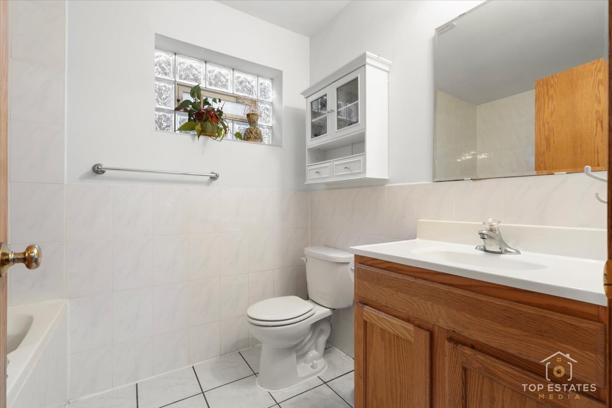 4629 South Laflin Street Chicago, IL 60609 - Photo 29 of 33 a bathroom with a sink a toilet and a mirror