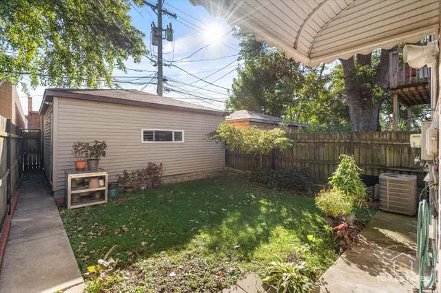 a backyard of a house with table and chairs potted plants