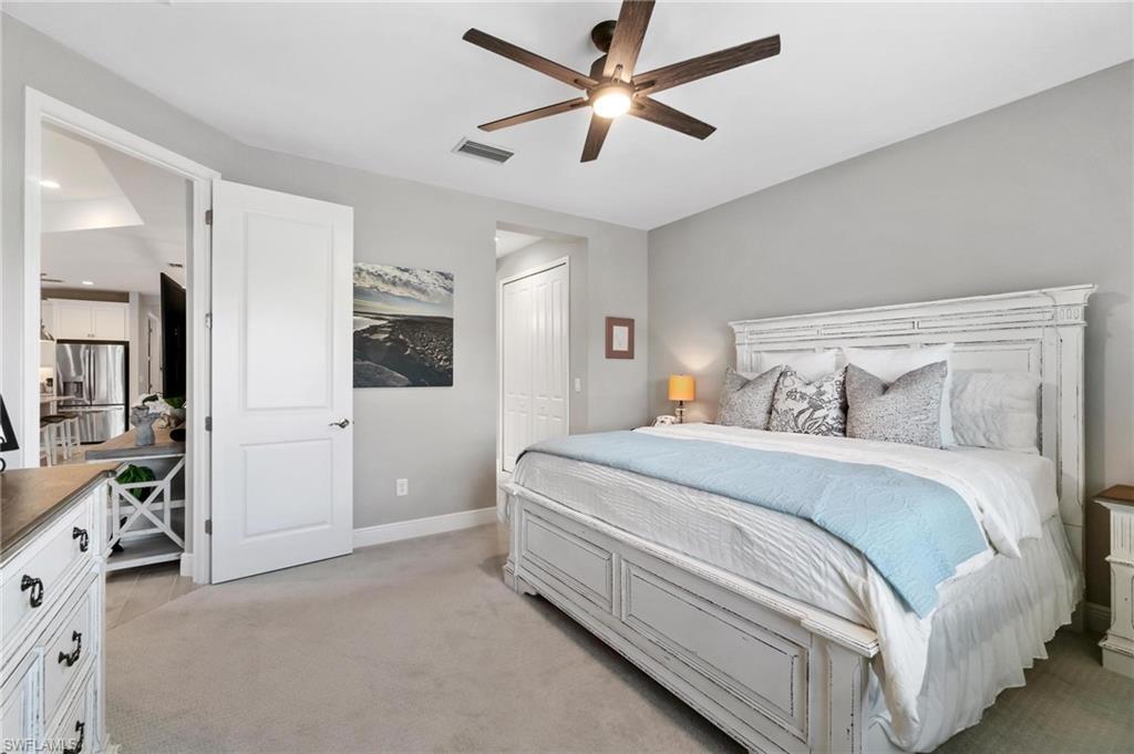2298 Marquesa Circle Naples, FL 34112 - Photo 12 of 50 a bedroom with a large bed and a ceiling fan