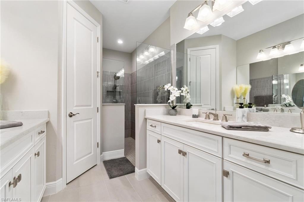 2298 Marquesa Circle Naples, FL 34112 - Photo 15 of 50 a bathroom with a double vanity sink and a mirror
