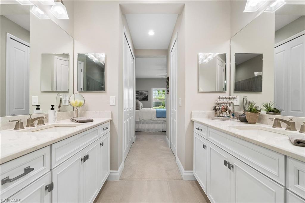 2298 Marquesa Circle Naples, FL 34112 - Photo 16 of 50 a spacious bathroom with a double vanity sink and mirror