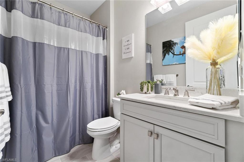2298 Marquesa Circle Naples, FL 34112 - Photo 18 of 50 a bathroom with a sink a toilet and shower curtain
