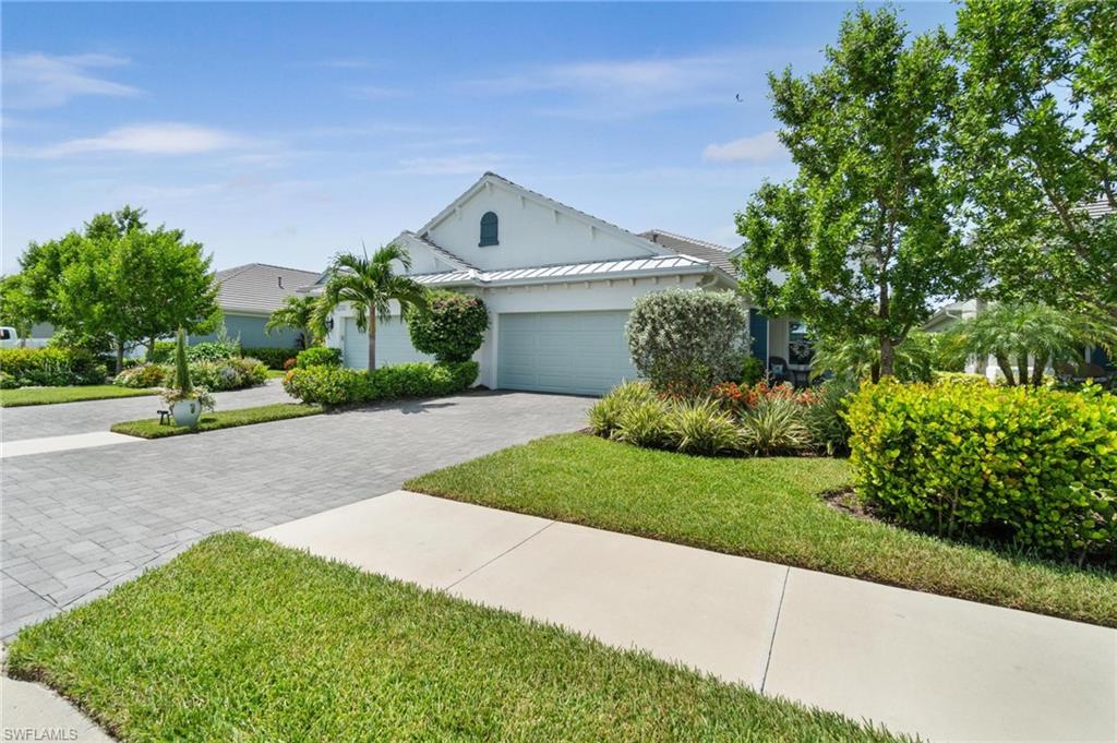 2298 Marquesa Circle Naples, FL 34112 - Photo 33 of 50 a front view of a house with a yard and garage