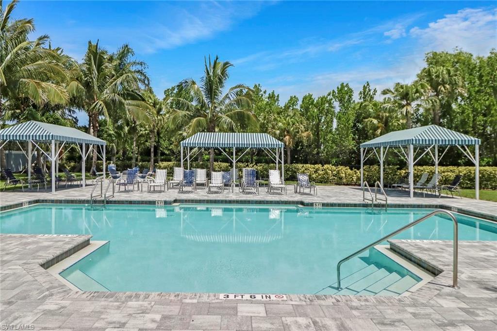 2298 Marquesa Circle Naples, FL 34112 - Photo 45 of 50 a view of a swimming pool with a table and chairs under an umbrella