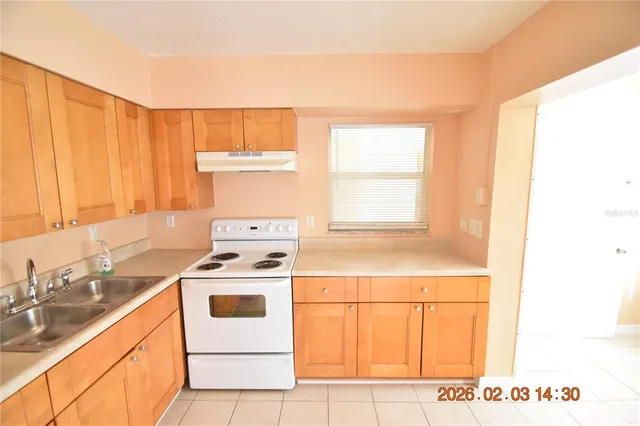 a kitchen with a stove a sink and a window