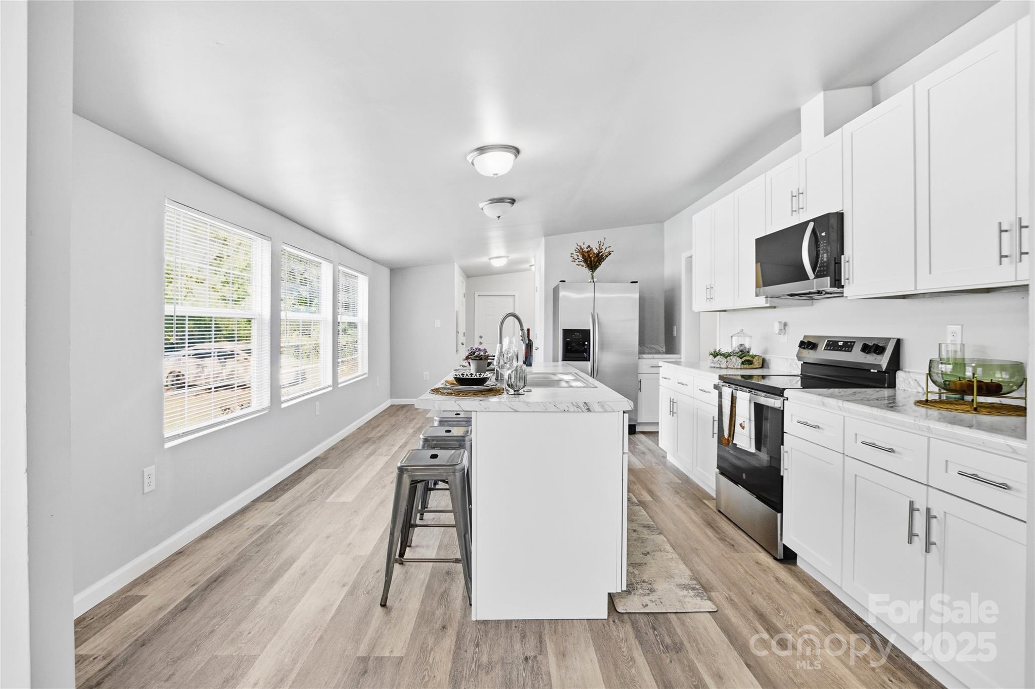 2425 Shoal Creek Church Road Shelby, NC 28152 - Photo 18 of 33 a kitchen with a stove a sink and white cabinets with wooden floor