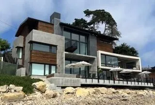 a front view of a house with swimming pool and patio