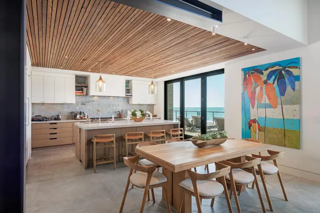 a kitchen with stainless steel appliances granite countertop a kitchen island a stove a table and chairs with wooden floor