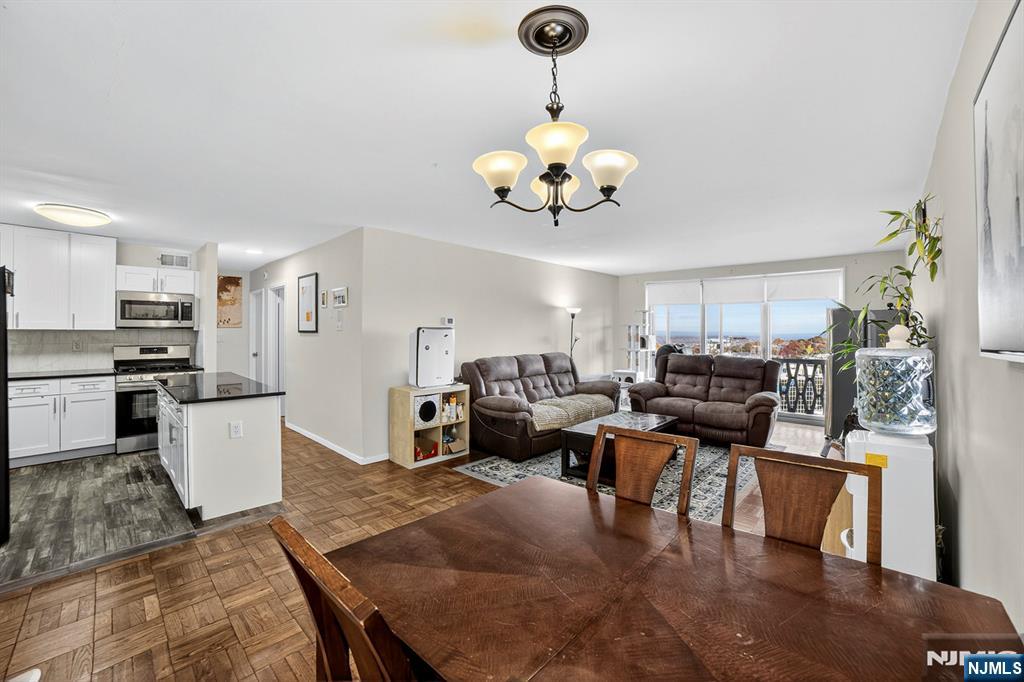 2100 Linwood Avenue, Unit 17U Fort Lee, NJ 07024 - Photo 13 of 23 a living room with furniture kitchen view and a chandelier