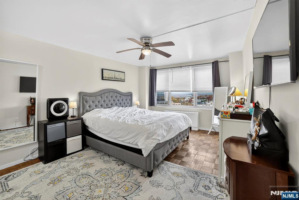 2100 Linwood Avenue, Unit 17U Fort Lee, NJ 07024 - Photo 17 of 23 a spacious bedroom with a bed and a chandelier