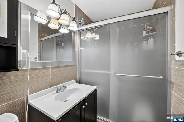 a bathroom with a sink mirror and a shower