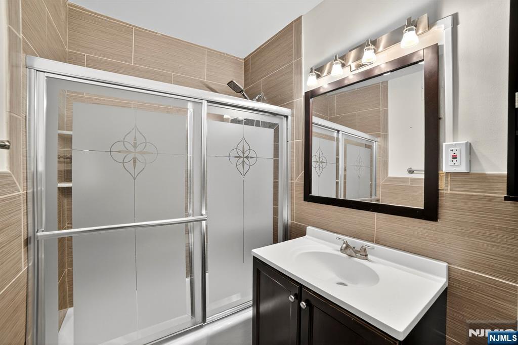 2100 Linwood Avenue, Unit 17U Fort Lee, NJ 07024 - Photo 22 of 23 a bathroom with a sink a mirror and a shower