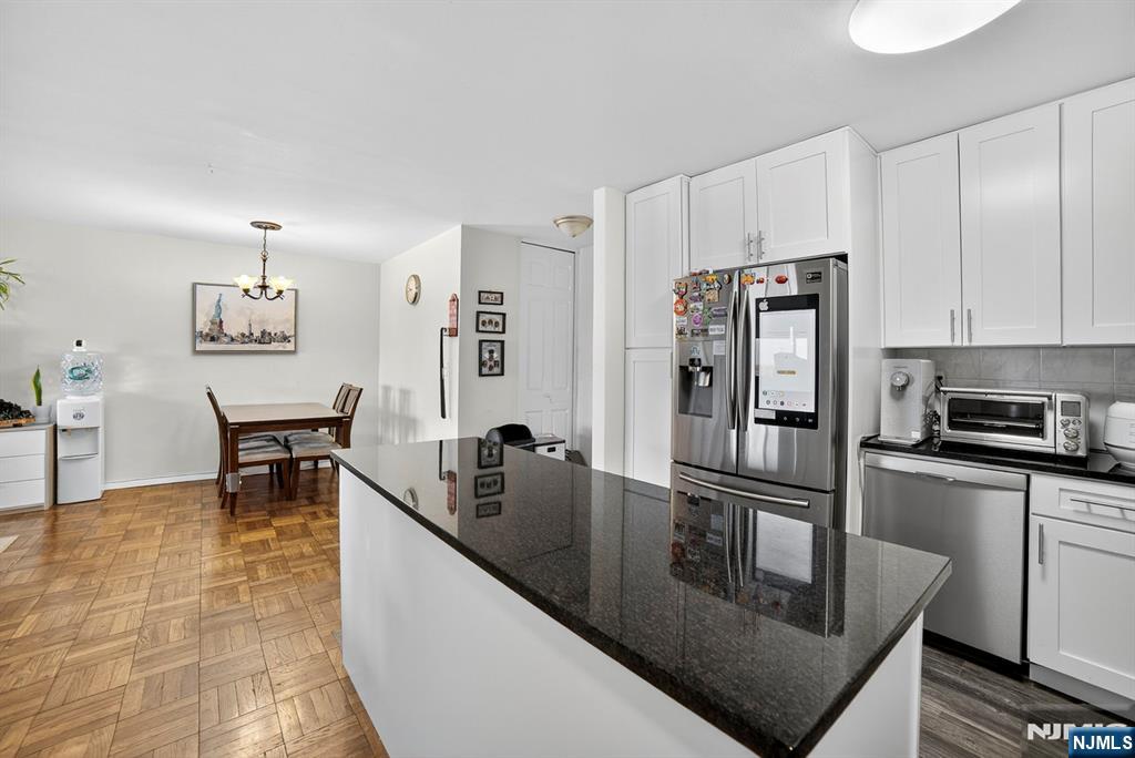 2100 Linwood Avenue, Unit 17U Fort Lee, NJ 07024 - Photo 8 of 23 a kitchen with stainless steel appliances granite countertop a refrigerator a stove a dining table and chairs