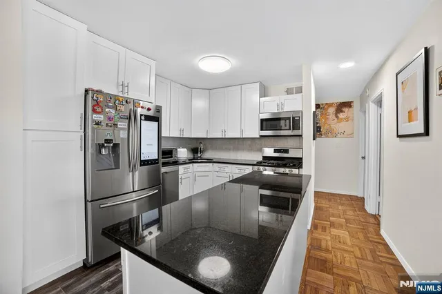 a kitchen with stainless steel appliances granite countertop a refrigerator a stove top oven a sink and dishwasher