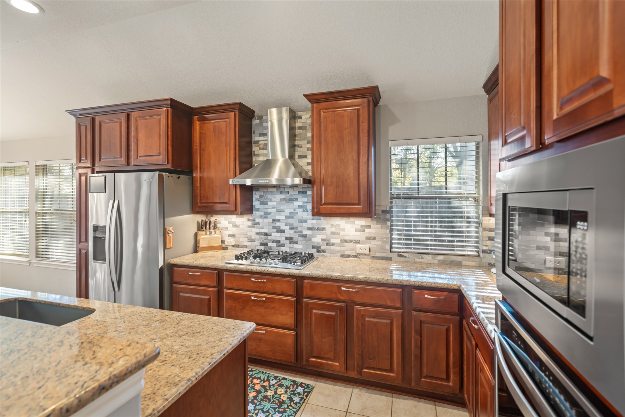 28318 Ryans Ridge Lane Spring, TX 77386 - Photo 20 of 48 a kitchen with stainless steel appliances granite countertop a refrigerator and wooden cabinets