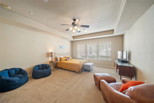 a spacious bedroom with a bed and a flat screen tv