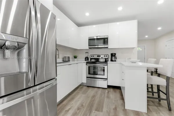 a kitchen with stainless steel appliances a refrigerator stove and microwave