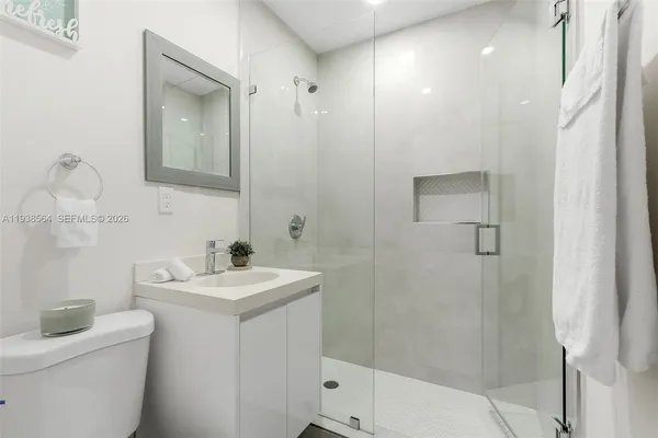 a bathroom with a sink a toilet and shower