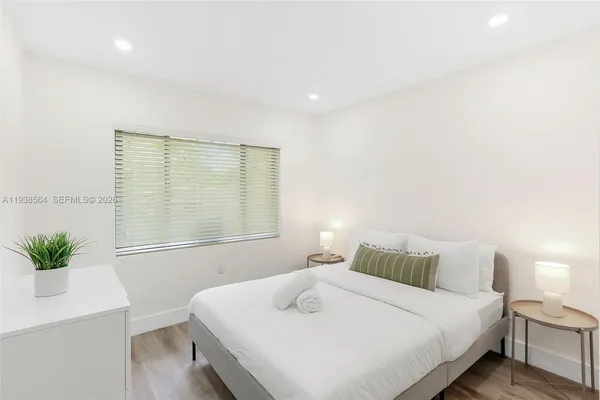 a bedroom with a bed and a potted plant