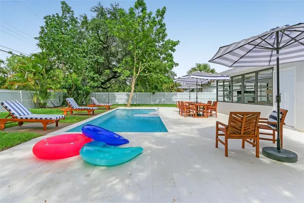 a view of a backyard with swimming pool and seating