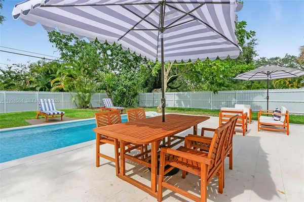 a view of a patio with a table and chairs under an umbrella