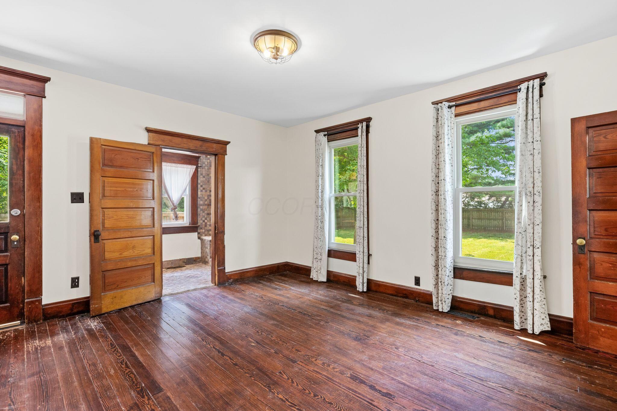 107 Price Road Columbus, OH 43230 - Photo 17 of 51 Interior room featuring wood-finish flooring, two windows, and a ceiling-mounted light fixture