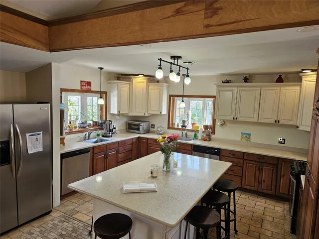 a large kitchen with kitchen island a sink counter space and stainless steel appliances