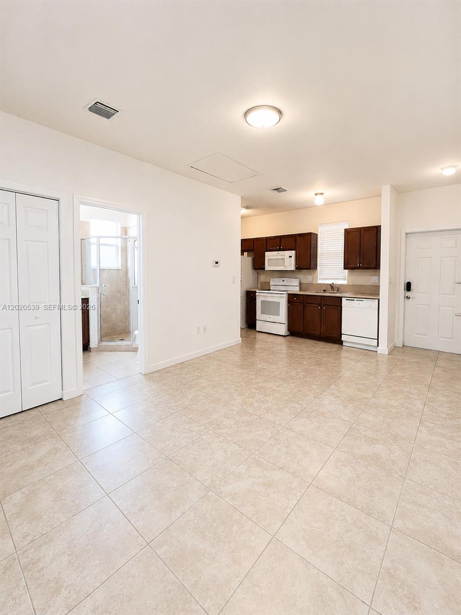 17001 Southwest 96th Street Miami, FL 33196 - Photo 18 of 23 a view of kitchen with kitchen island microwave and refrigerator