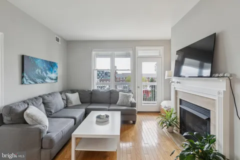 a living room with furniture a flat screen tv and a fireplace