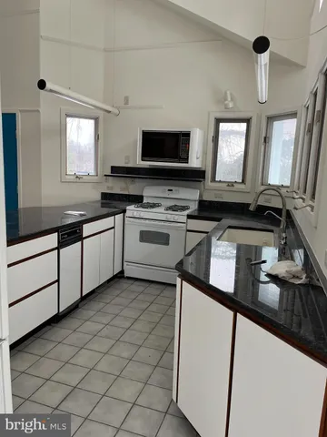 a kitchen with stainless steel appliances granite countertop a sink and a stove