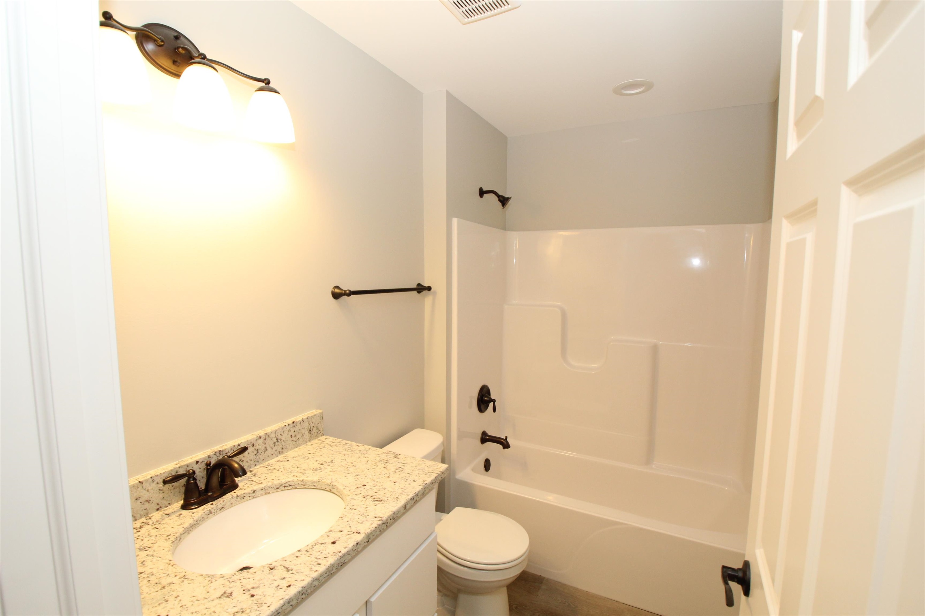 11235 Dublin Drive Roscoe, IL 61073 - Photo 13 of 20 a bathroom with a granite countertop sink a toilet and shower