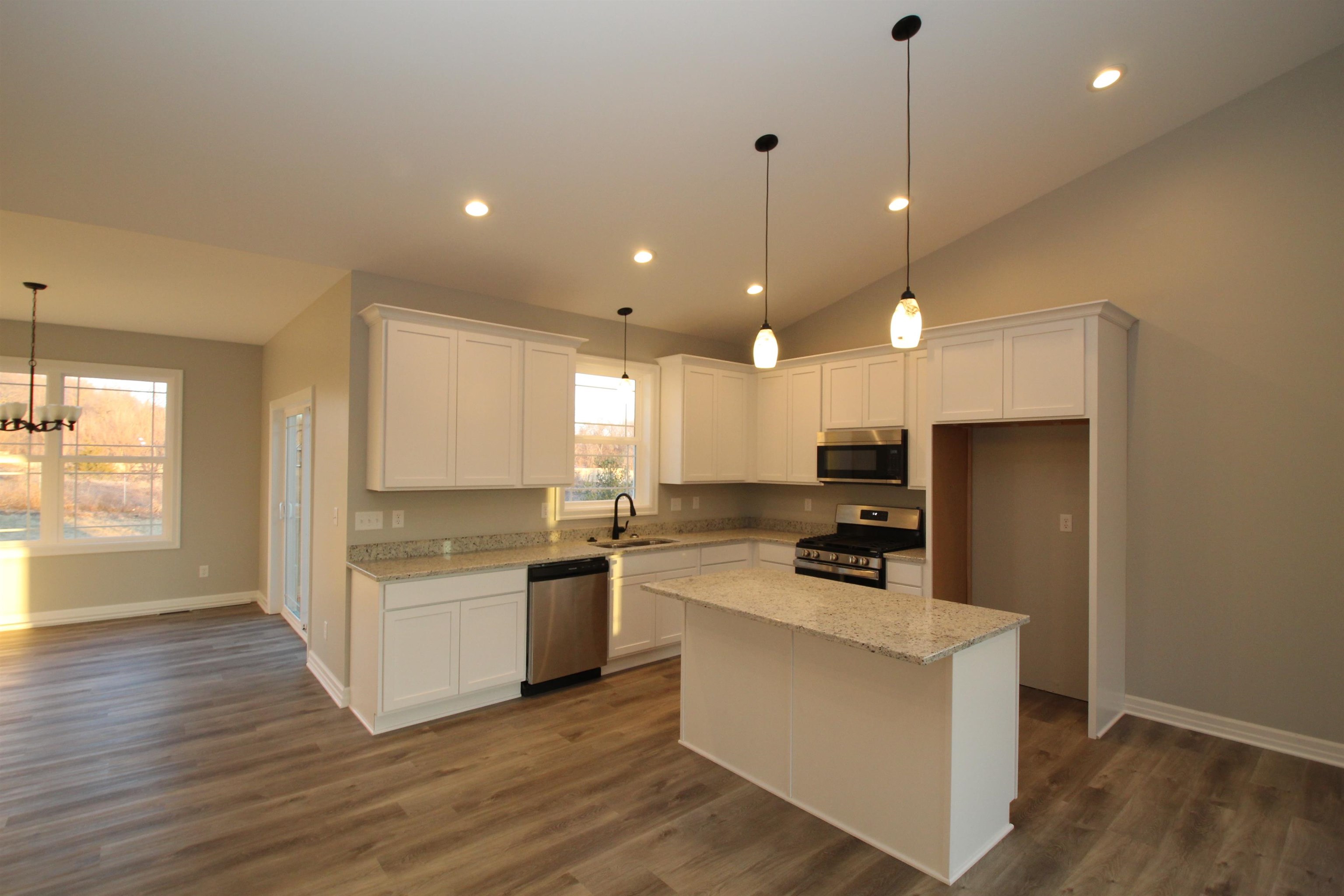 11235 Dublin Drive Roscoe, IL 61073 - Photo 6 of 20 a kitchen with a refrigerator a stove top oven a sink dishwasher and white cabinets with wooden floor