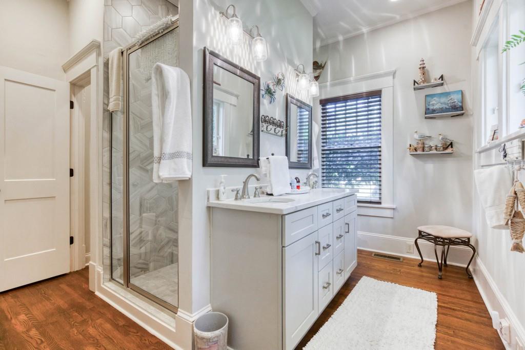 304 Edwards Street Monroe, GA 30655 - Photo 20 of 64 a bathroom with a double vanity sink a mirror and a shower