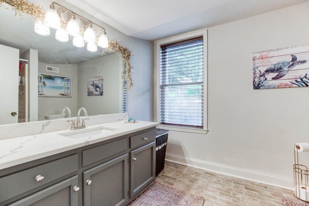 304 Edwards Street Monroe, GA 30655 - Photo 40 of 64 a spacious bathroom with a granite countertop double vanity sink a mirror and a window