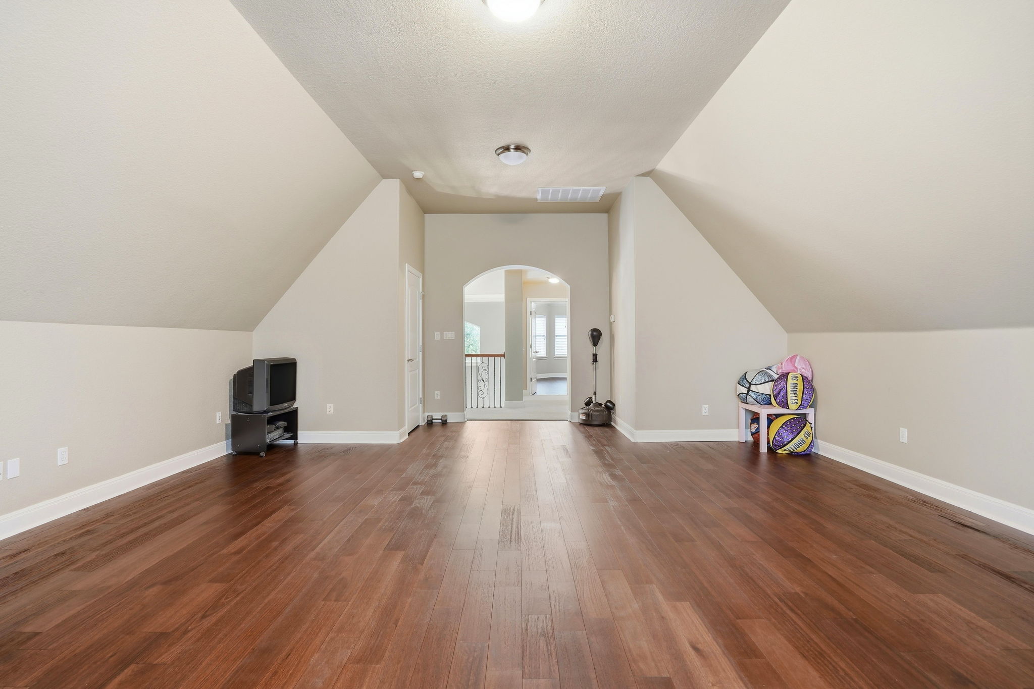 222 Vailco Lane Austin, TX 78738 - Photo 38 of 39 Spacious bonus room featuring wood-finish flooring, sloped ceilings, and an arched doorway